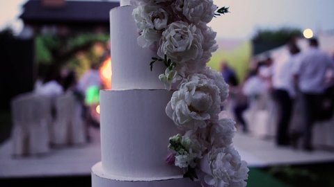 big beautiful wedding cake in the evening near the arch