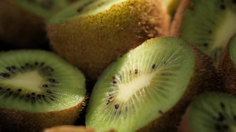 Kiwi fruit. Camera moves slowly and showing cutting kiwi fruits in shadow with sunlight beam shining. Macro shot