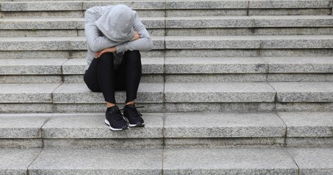 Upset woman sitting alone in city stairs