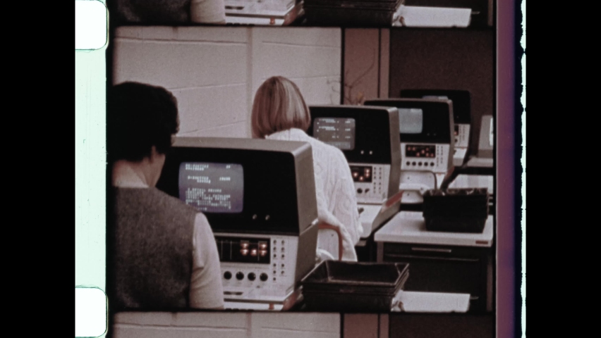 1960s Cupertino, CA. Vintage Computer Technology. Two women work on old computers in data center. 4K Overscan of Vintage Archival 16mm film print