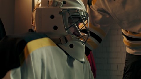 Teammates cheering up their goaltender in the locker room during the intermission. Shoot with 2x anamorphic lens
