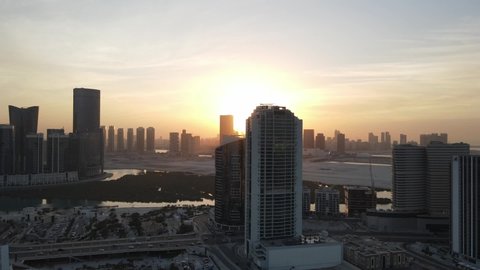 Sunset in Abu Dhabi, aerial view on Al Reem island surrounded by modern skyscrapers between the mangroves in the sea