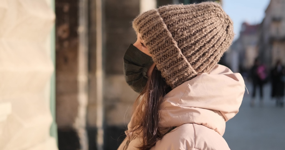 Woman in hooded jacket and knit hat with protective face mask outdoors Royalty-Free Stock Footage #1085396198