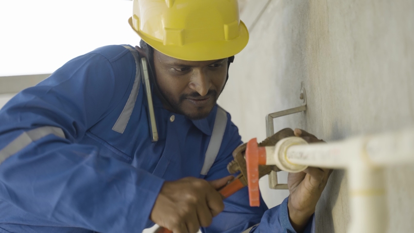 Plumber or repairman talking on mobile phone with colleague while fixing pipe using wrench - concept of communication, teamwork and technology Royalty-Free Stock Footage #1085401784