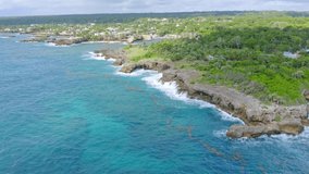 Sea waves break on rocky coast of Boca de Yuma in Dominican Republic. Aerial forward