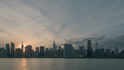 New York, NY, USA - May 2nd 2021: Sunset of NYC viewed from Gantry Park in LIC.  In view are the Empire State Building, Chrysler Building and the United Nations. NYC Ferry boats can be seen.  