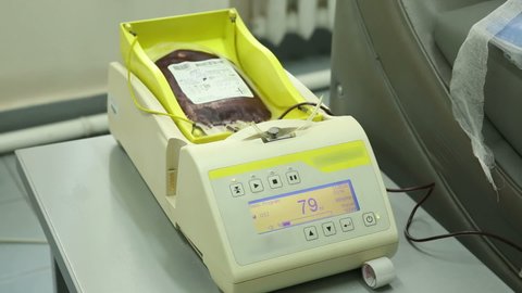 Take blood from volunteers at donor center. The nurse puts a tourniquet on arm, pricks needle into patients arm. Transfusion Machine Collects Blood Plasma