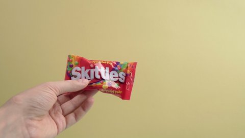 Tyumen, Russia-December 27, 2021: Original Skittles brand candies. Yellow background. delicious sweet skittles