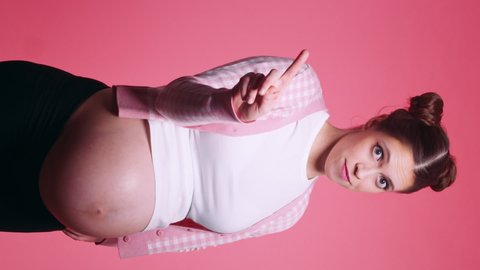 Young caucasian pregnant brunette young woman with a serious attitude shows a NO gesture with crossed protests against. Young mother. Dont do it, stop it. Vertical video