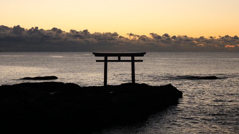 The calm sea on a winter morning and the torii gate of a Japanese shrine. Oarai town in Japan.