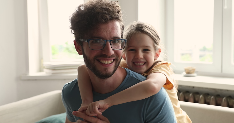 Close up portrait of happy young father and his little, cute daughter. Preschool girl piggy back his loving daddy, cheerful attractive family smile looking at camera. Bonding, fatherhood, bond concept Royalty-Free Stock Footage #1085422418