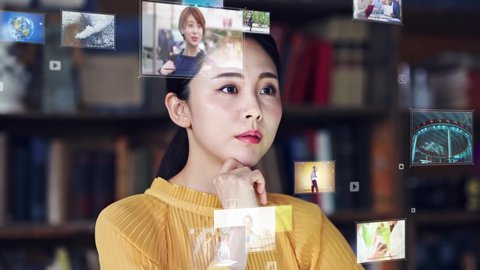 Young Asian woman watching Hologram screens. Head up display. Video distribution service. Virtual reality. Metaverse.