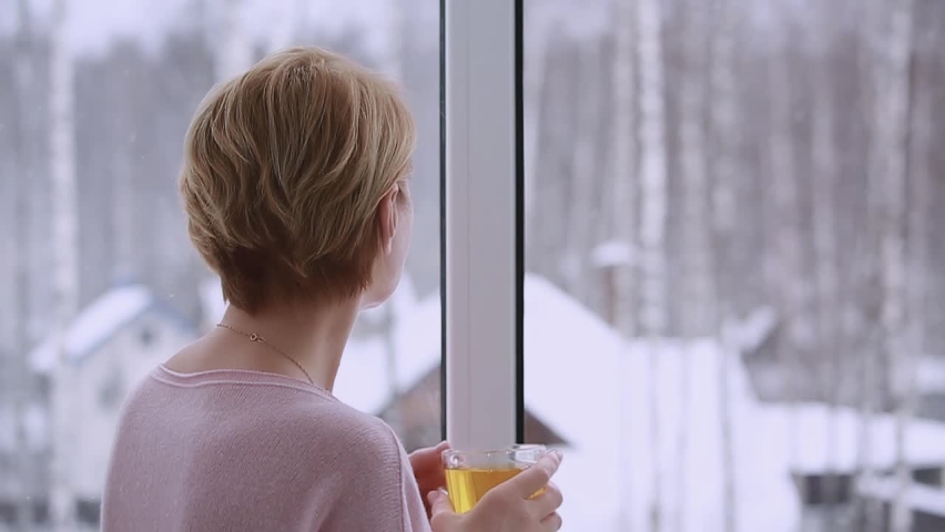 A woman looking out the window in winter