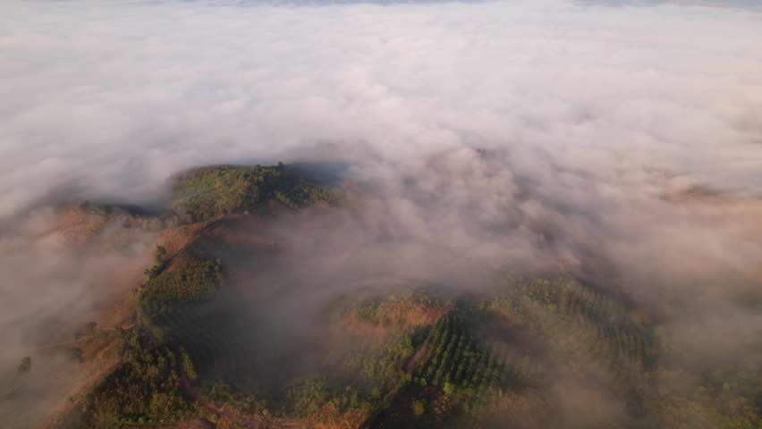 4K aerial view over a misty mountainous area. The great golden sun in the morning
