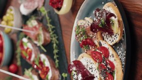 Vertical video, Italian restaurant with traditional food, Spanish cuisine, delicious tapas and white wine, bruschetta with cheese, olives dry tomatoes and tasty sandwich bar appetizer, buffet 
