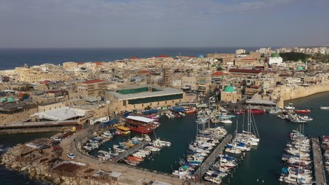 Panoramic aerial view of vessels in small port of Akko (Acre), with historic old town in the background. Historic architecture and tourism in Israel. 