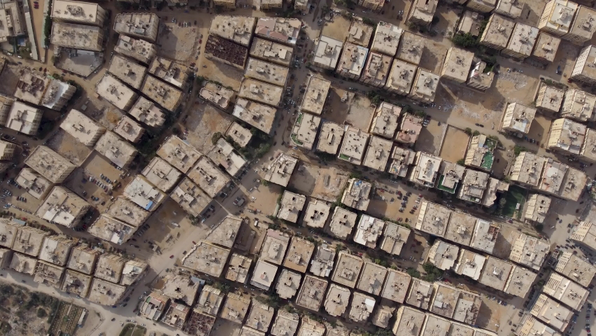 Aerial top down view of Pyramids Gardenscity building block located in Giza - Egypt flight over roofs and streets with vehicles driving around filmed by drone moving up slowly.