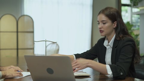 couple talking and working with laptop computer together in office.  business woman take note from discussion with customer. lawyer Write a message from a conversation with a client.