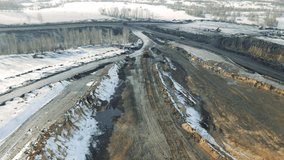 Aerial view of a working quarry. drone video, coal mining. Machines are working. Ruined landscape. Violation of nature. Dust and water pollution.