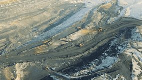 Aerial view of a working quarry. drone video, coal mining. Machines are working. Ruined landscape. Violation of nature. Dust and water pollution.