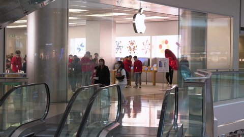 Hong Kong , Kowloon , China - 01 09 2022: Shoppers walk past the multinational American technology brand Apple official store and logo at a shopping mall in Hong Kong.