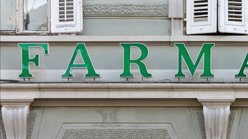 Italian and spanish pharmacy sign over the facade of a building Royalty-Free Stock Footage #1085451830