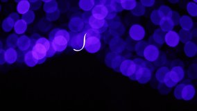 writing of a white merry christmas animation with calligraphy lettering on dark blue with bokeh background