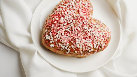 Valentines Day food, festive dinner. Heart shaped cake sprinkled confectionary icing.