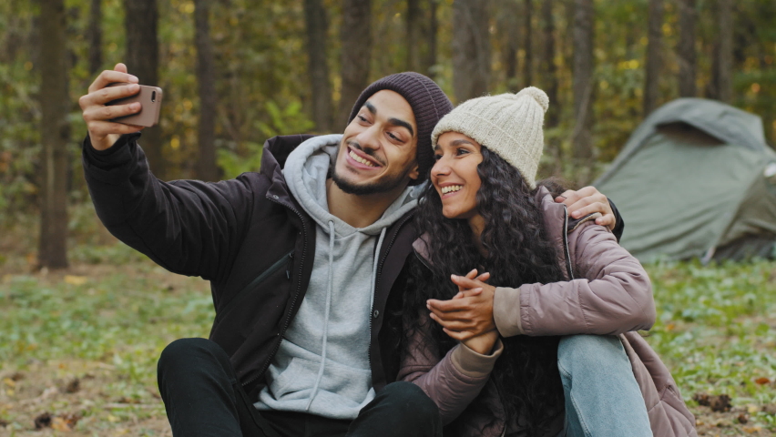 Young couple making video call using smartphone at sunny green autumn forest background. Hiking of emotionally travelers spending weekend in wild side. Enjoyment, friendly moments, funny time outdoor Royalty-Free Stock Footage #1085463227