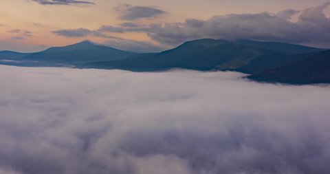 Morning traditional alpine landscape in the Carpathians, Ukraine, sunrise after rain, fast running seas and rivers of fog timelapse video