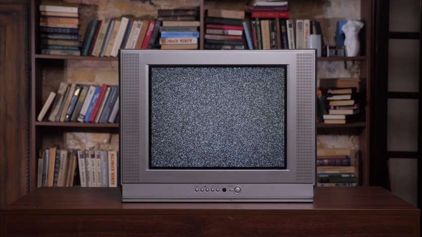 Old books background retro television set. Room old tv set. 90s retro tv screen static noise. Analog static effect retro tv room interior home library bookshelf background. Bad television signal noise Royalty-Free Stock Footage #1085464997