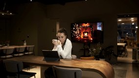 A girl with dreadlocks in a white shirt using a digital tablet device at an online lesson, learns from video through a tablet. Online learning concept.