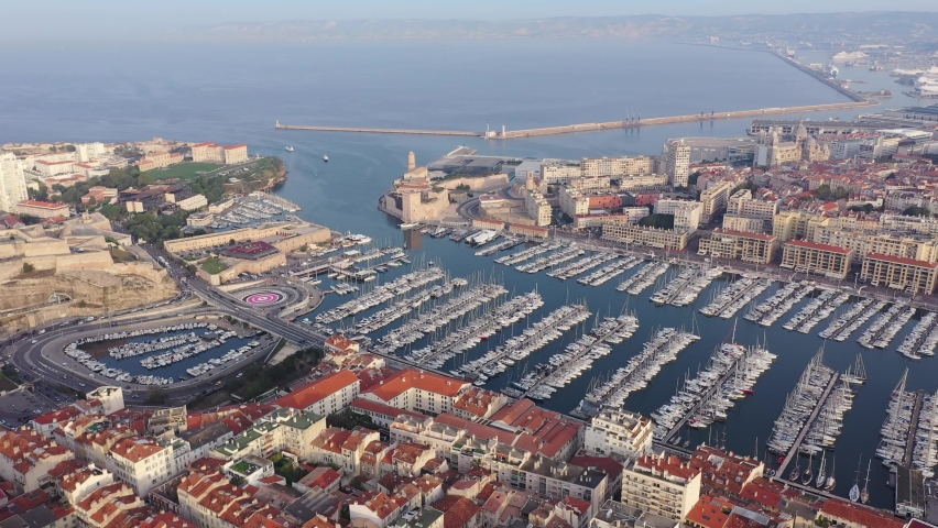 Picturesque drone view of modern Marseille cityscape on Mediterranean coast overlooking large Old Port with moored pleasure yachts on sunny day, France