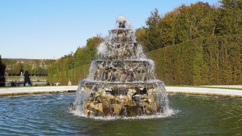 Versailles, France - October 24, 2021: The Pyramid Fountain (by sculptor Francois Girardon 1628-1715) in gardens of famous Versailles palace. Neptune Fountain in the background.
