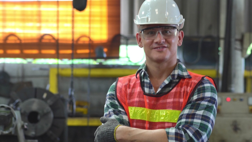 Portrait of confident engineer foreman in arms crossed showing thumbs up and smiling to camera at the industrial factory. blue collar worker at construction site Royalty-Free Stock Footage #1085477816
