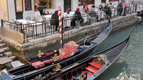 Venice, Italy FEBRUARY, 18, 2017 Luxury gondola, typical boat of Venice, with a couple of Caucasian tourists in a canal. 