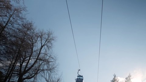 Bansko, Bulgaria - December 25, 2021: Gondola lift with skiers moving upwards, view from below.