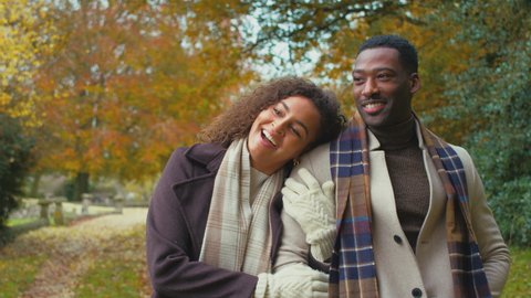 Young romantic couple walking arm in arm in autumn countryside - shot in slow motion Stockvideo