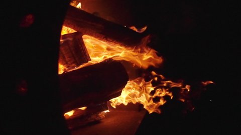 Vertical slow motion footage of flames burning in a campfire.