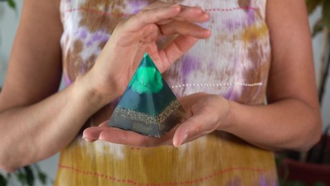 Middle-aged woman with green orgone stone pyramid