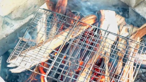 grill grate lies on burning wood in the hearth