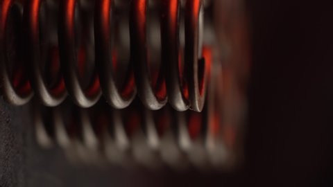 closeup of engine head spring, red reflections, for perfomance and tuning motor, vertical shot