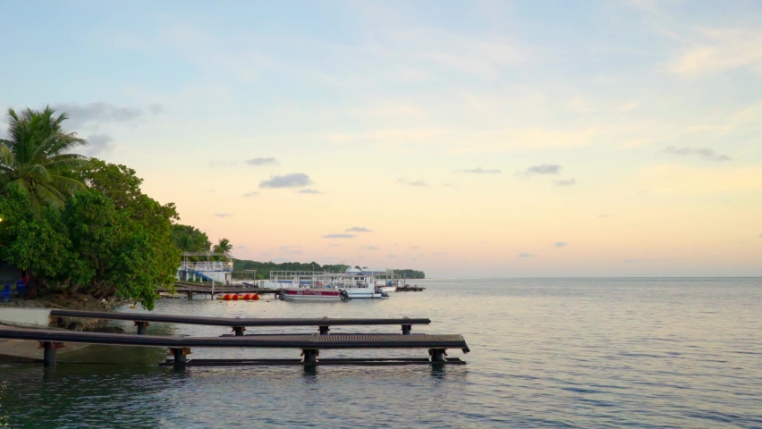 Boats docked on a pier at sunset