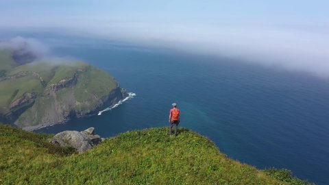 Traveler Standing on Edge of Shikotan Island, and Looking on Pacific Ocean, Lesser Kuril Chain, Russia. Drone Shot.