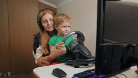 Mother with boy playing racing on game steering wheel