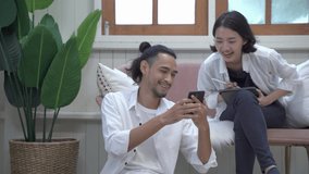 Young woman relax on cozy sofa furniture in living room using browsing Internet on tablet, Smiling young Asian couple sit relax on modern comfortable couch at home using smartphone together. - Powered by Shutterstock - Get 15% off with code: PIKWIZARD15