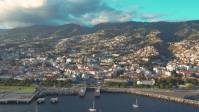 Aerial 4K footage of a drone flight over Funchal coastline in Madeira island in the evening