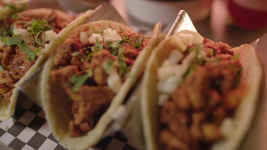  Traditional mexican pork tacos called "Al pastor" with pineapple adding green sauce . Adding spicy sauce to freshly cooked Mexican tacos. Royalty-Free Stock Footage #1085512517