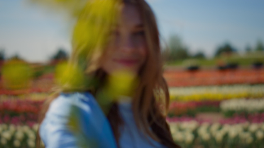 Portrait of smiling woman dancing in flower field outdoors. Flirty girl with long red hair turning around in spring park. Closeup young female person feeling free in blooming garden in summer day. Royalty-Free Stock Footage #1085515565