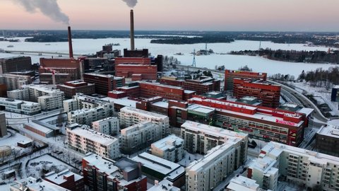 Helsinki , Finland - 12 26 2021: Aerial view of smoking chimneys, winter sunset in Helsinki, Finland - tracking, drone shot	